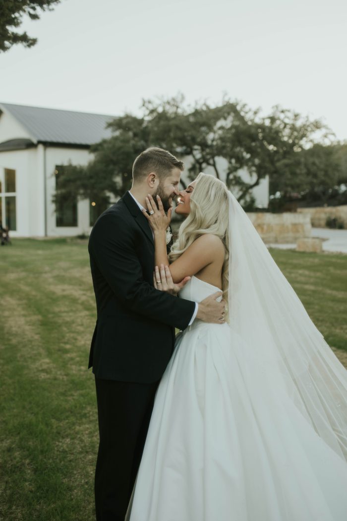 Bride wearing Derrick satin wedding dress by Maggie Sottero