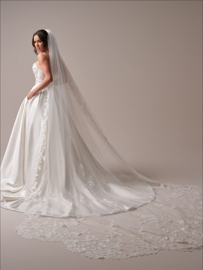 Bride wearing a simple ballgown wedding dress with a cathedral length veil
