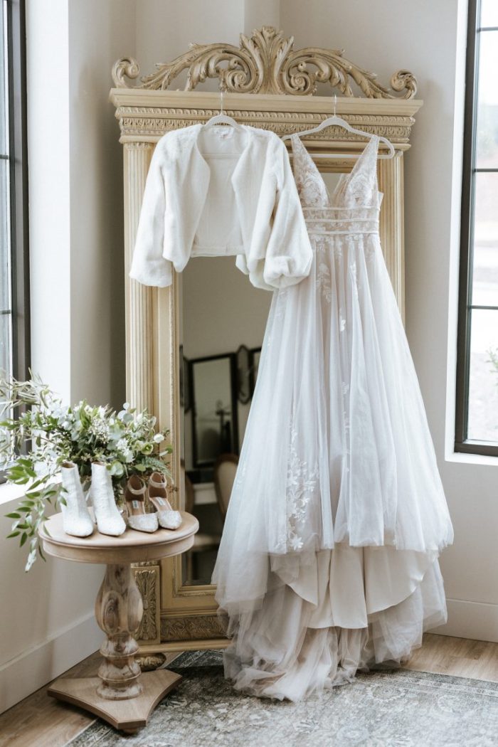 Raelynn winter wedding dress hanging up with bridal accessories