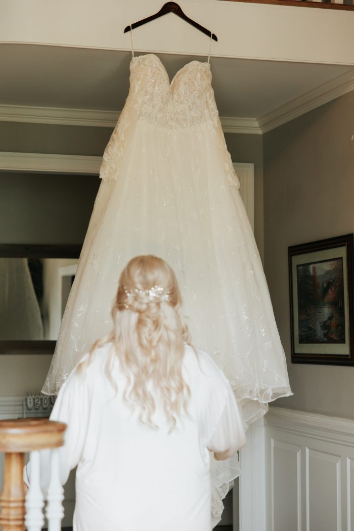 Brittany looking at one of Maggie Sottero's maternity wedding dresses