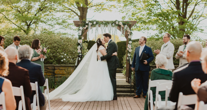 Bride wearing a Maggie Sottero wedding dress kissing her husband