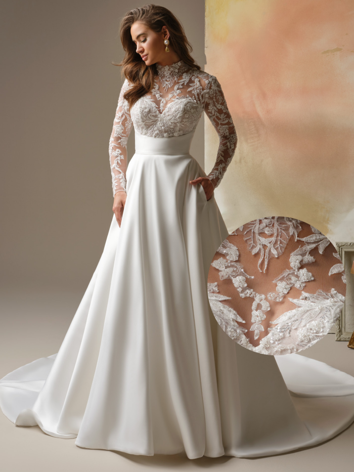 Bride wearing the Trinity by Maggie Sottero, an elegant A-line wedding dress with a high illusion lace neckline, long embroidered lace sleeves, a fitted lace bodice, and a clean satin skirt with pockets, photographed in a softly styled studio setting.