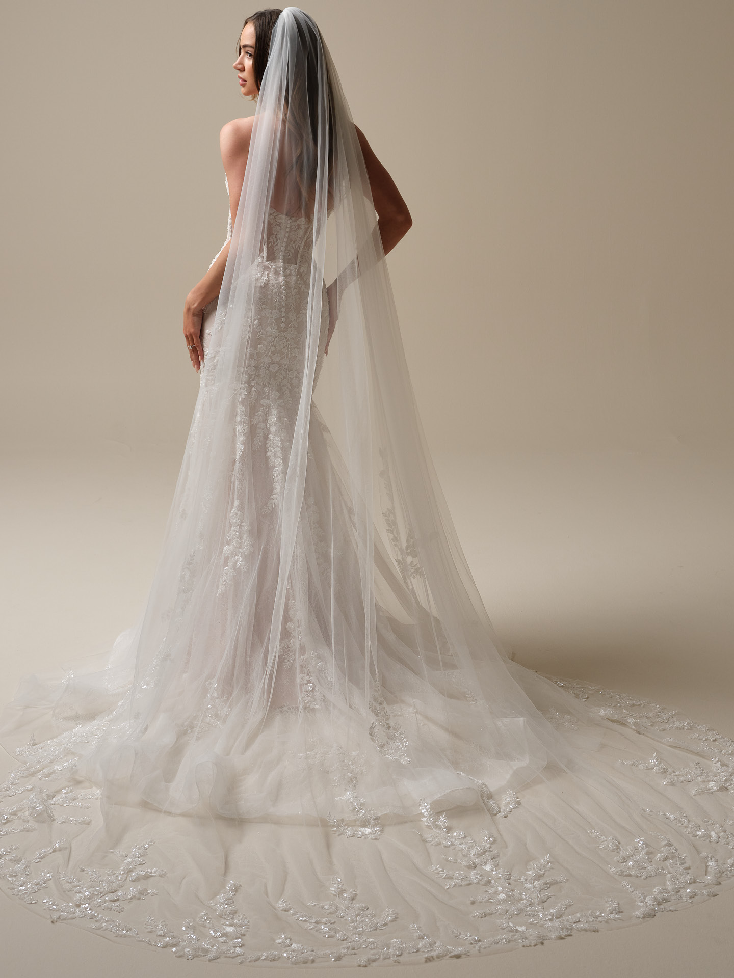 Chapel-length veil in soft sheer tulle with delicate embroidered lace edging, extending just beyond the gown’s train for a graceful, sweeping finish.