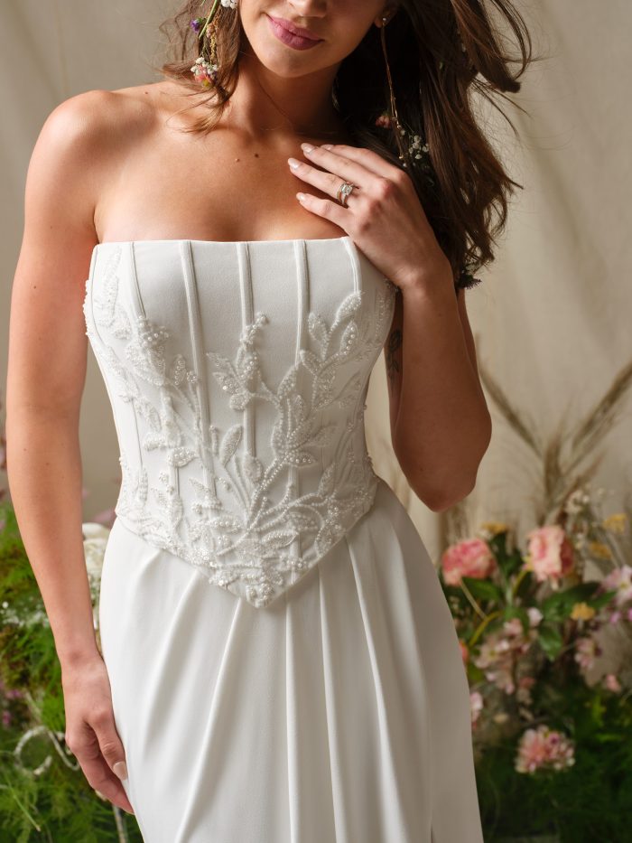 Close-up of the Terry wedding dress featuring a strapless structured bodice with embroidered floral detailing and clean seaming.