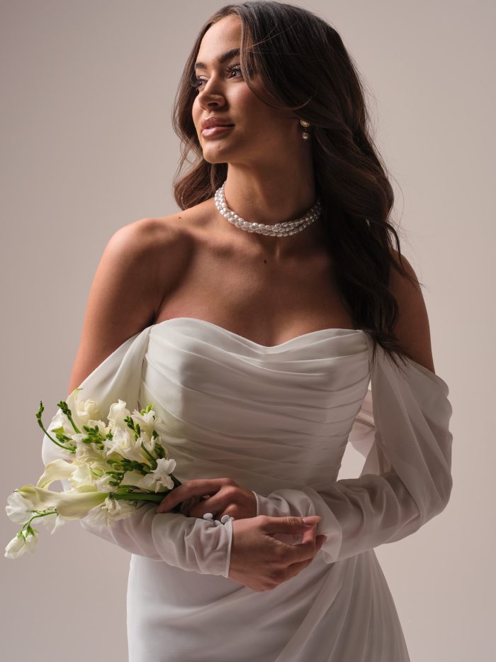 Bride wearing off-the-shoulder long sleeve wedding gown