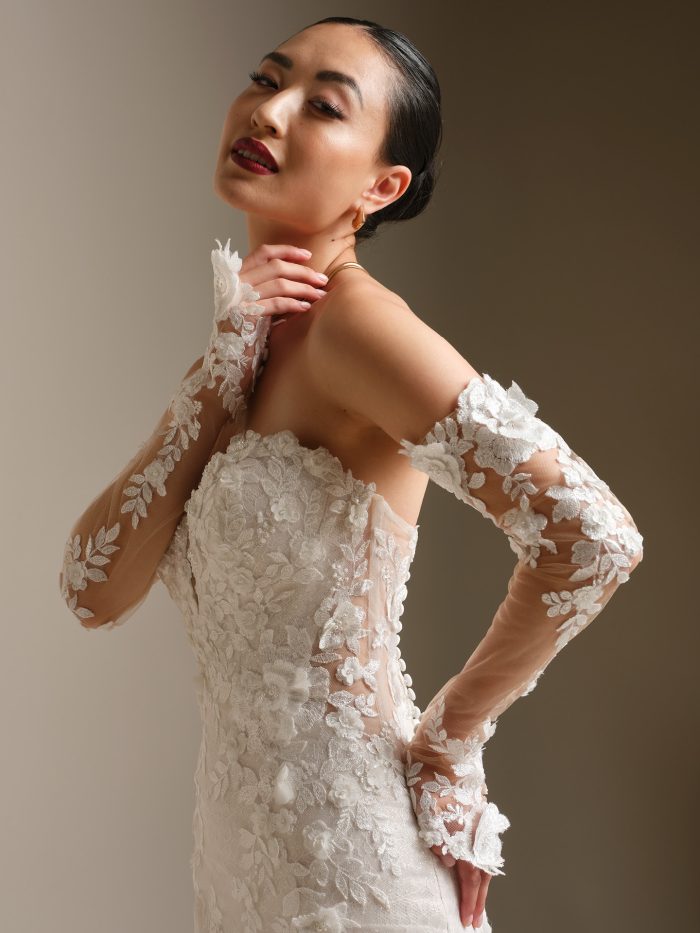 Close-up of the Sottero and Midgley Rashida wedding dress highlighting the strapless illusion lace bodice, off-the-shoulder floral lace sleeves, and sculpted fit-and-flare design.