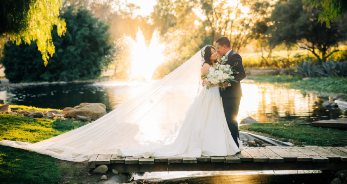 Bride wearing ball gown wedding dress by Maggie Sottero kissing her husband