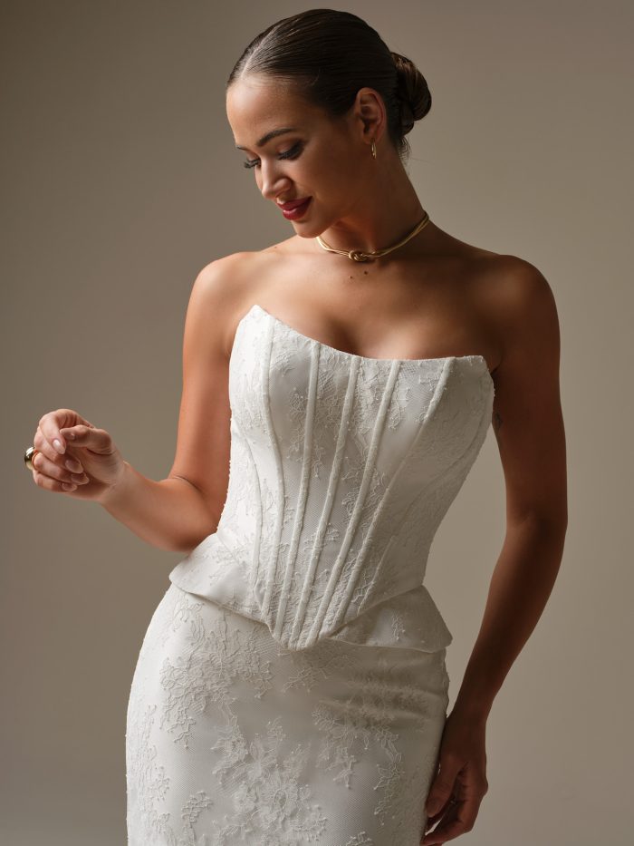 A close-up of the Sottero and Midgley Lassen wedding dress showing the strapless cat-eye neckline, two-piece corset bodice with boning and unembellished Chantilly lace detailing.