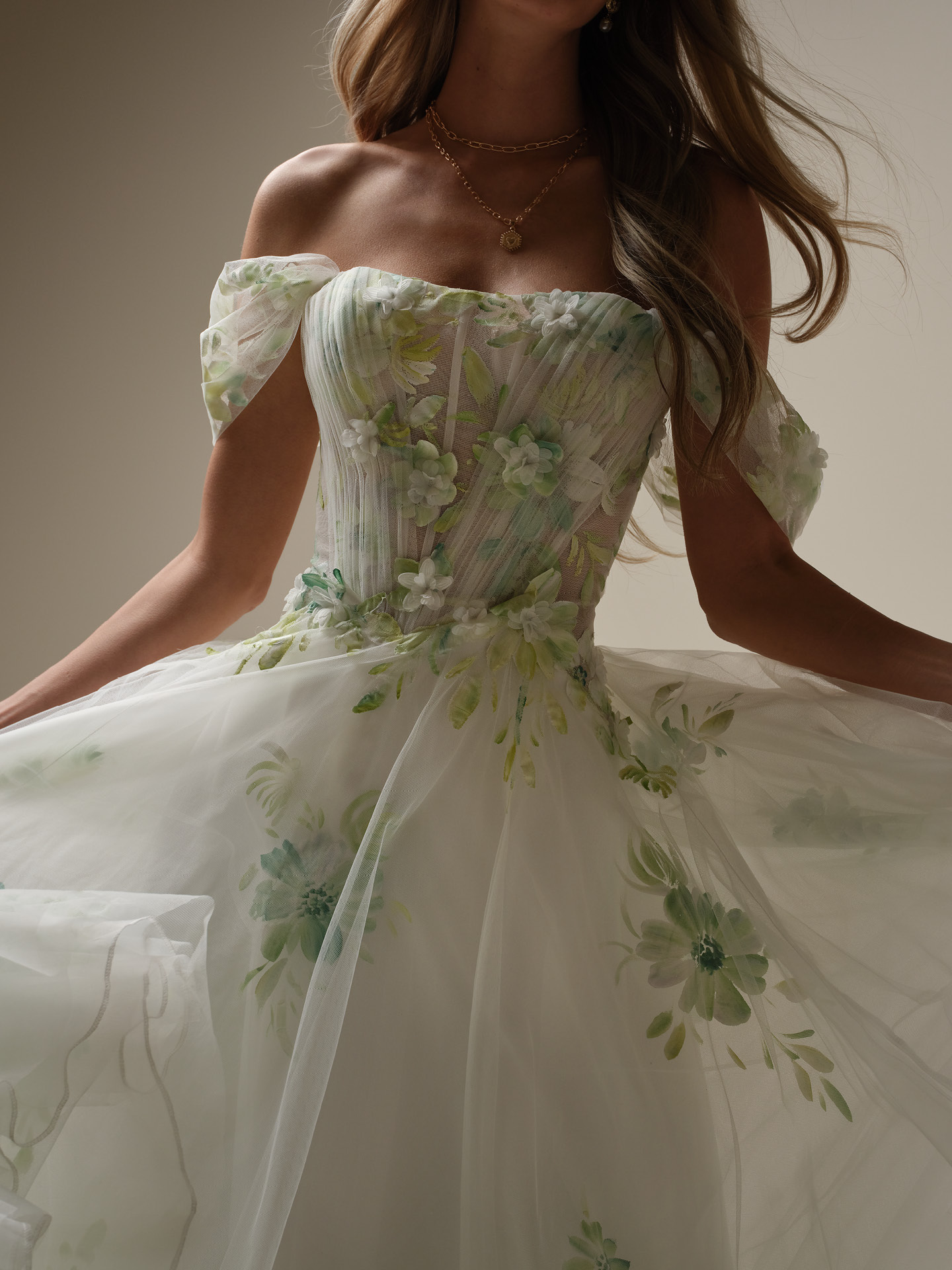 Close-up of off-the-shoulder wedding dress with hand-painted floral tulle, 3D flowers, and corset bodice