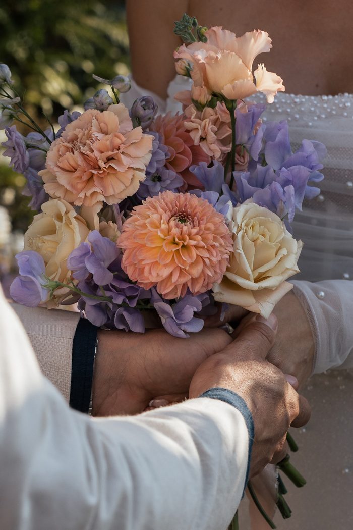 Bride wearing Drew Marie by Maggie Sottero holding flowers