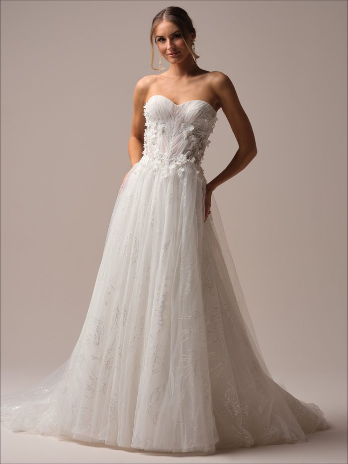 Full-length view of the Ireland A-line wedding dress by Maggie Sottero, featuring a strapless sweetheart neckline with ruched bodice and 3D floral appliqué, paired with a sparkling glitter tulle A-line skirt with a sweeping train.