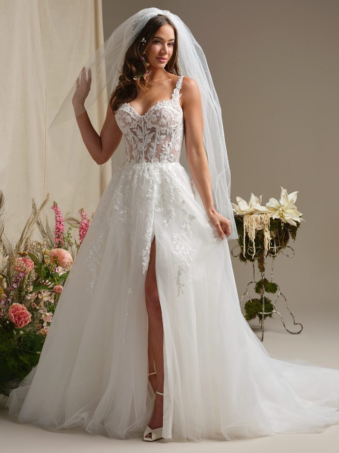 ull-length view of the Susan ball gown wedding dress by Rebecca Ingram, featuring a sheer lace bodice with beaded straps, a sweetheart neckline, and a flowing tulle ball gown skirt with a front leg slit and floral lace appliqué, paired with a beaded cathedral veil.