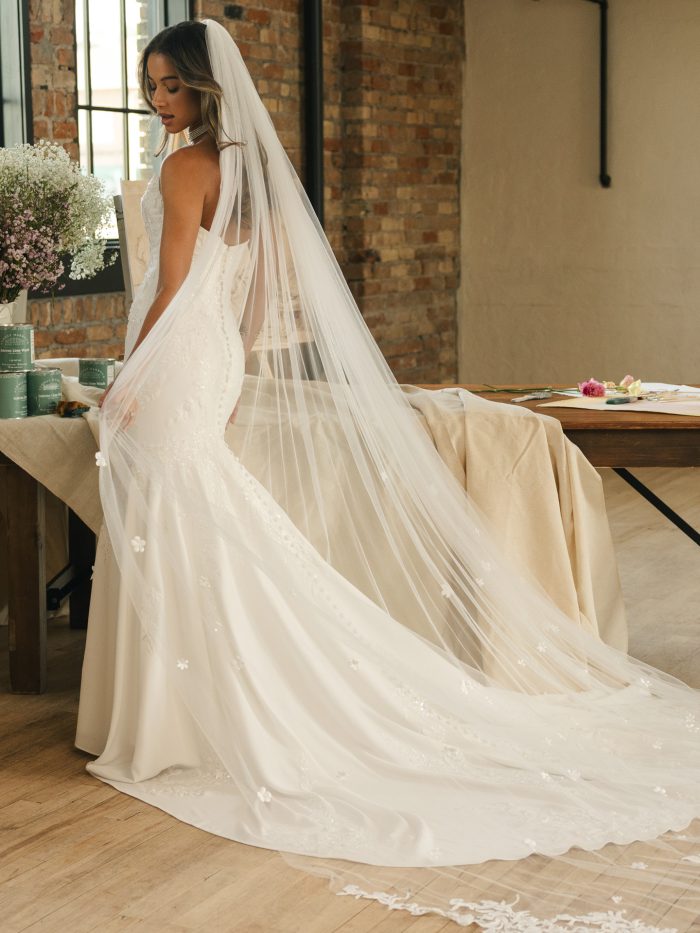 Side and back view of the Thera veil by Maggie Sottero, showcasing its long flowing tulle, delicate floral details, and soft romantic movement over a fitted bridal gown.