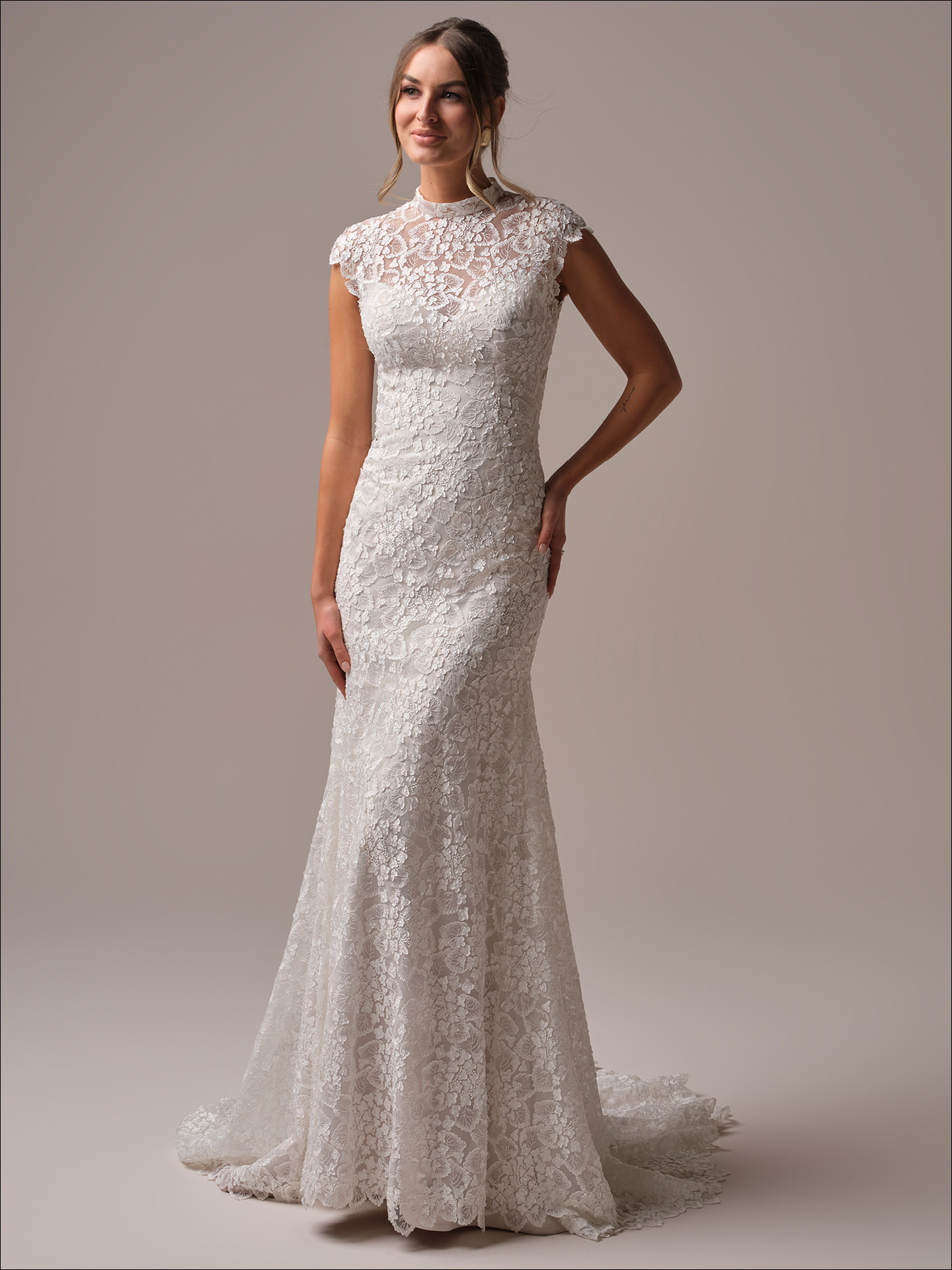 Maggie Sottero Auburn sheath wedding dress with high illusion lace neckline and cap sleeves, featuring allover floral lace for a vintage-inspired, boho bridal look