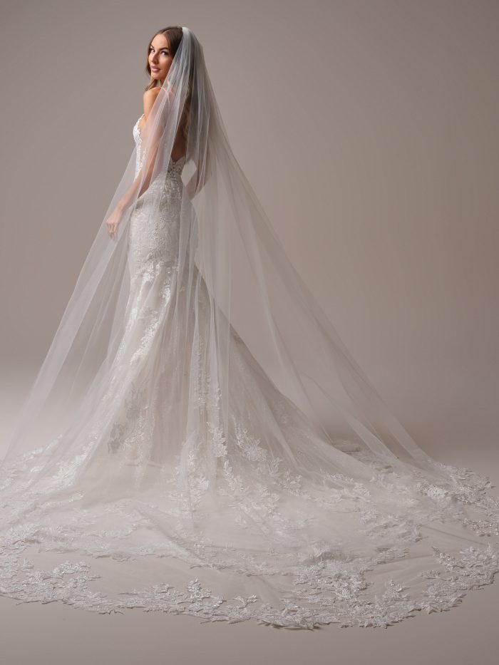 Maggie Sottero Bianca cathedral veil featuring soft tulle and scattered white floral appliqués. A romantic and whimsical long veil that adds delicate texture and elegance to any bridal look.