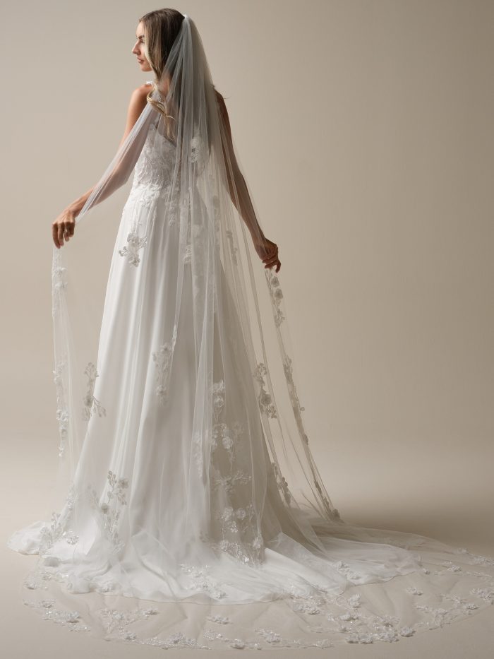 Maggie Sottero Hunter veil featuring chapel-length tulle with delicate 3D floral appliqués and scattered beaded embroidery. This romantic bridal veil perfectly complements the Hunter A-line wedding dress for a soft, ethereal wedding day look.