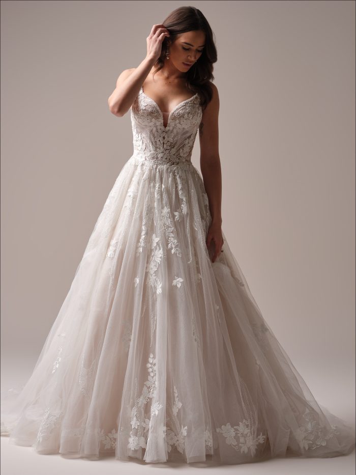 Bride in Liberty, a soft A-line wedding dress featuring floral motifs, deep illusion neckline, and shimmering layers—ideal for Gen Z brides wanting dreamy detail with modern vibes.