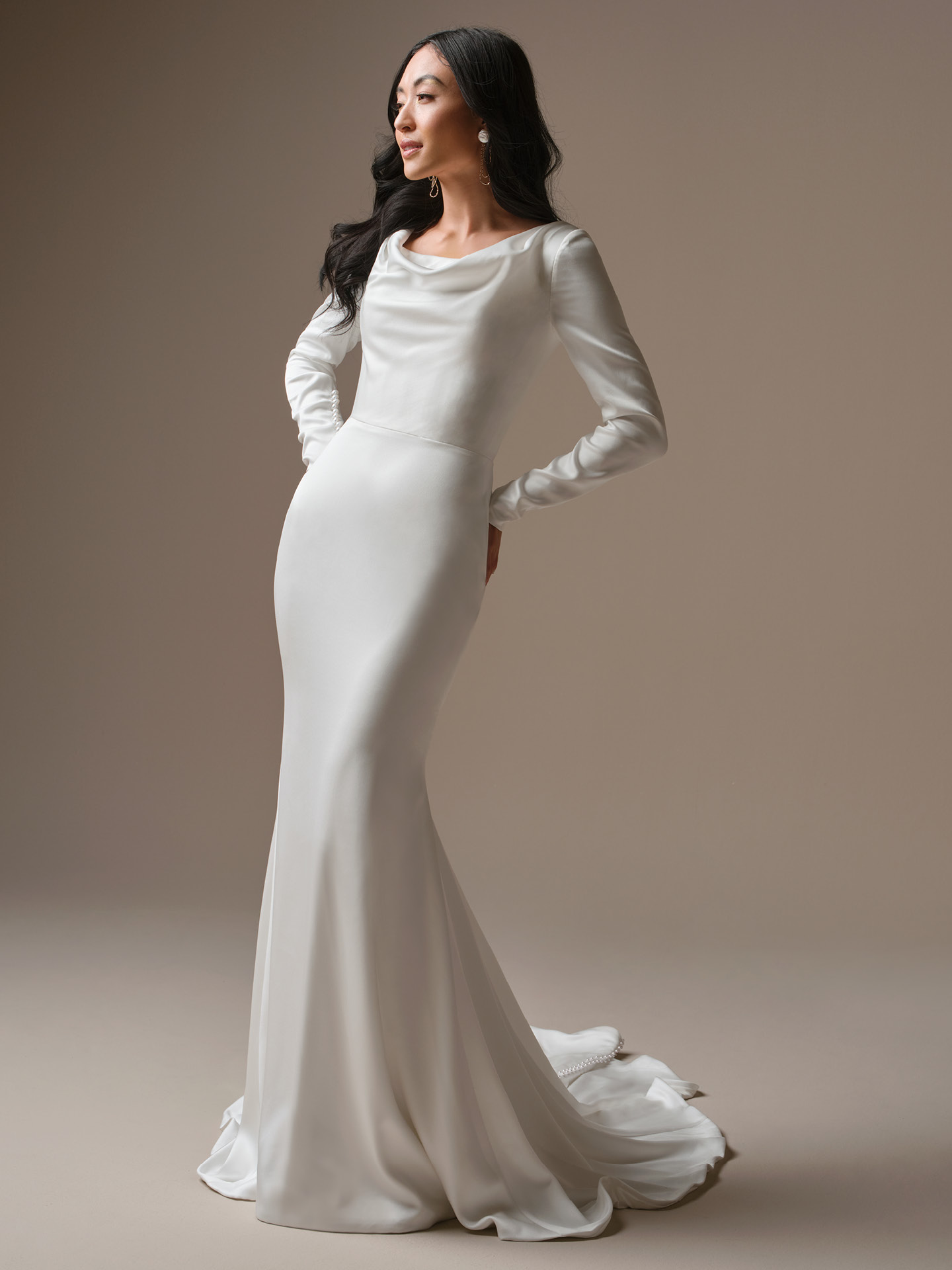 Maggie Sottero Melinda sheath wedding dress with draped cowl neckline and long sleeves, featuring a sleek satin silhouette for a modern, elegant bridal look