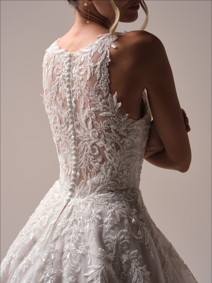 Close-up back view of the Nina A-line wedding dress, highlighting the illusion lace back with covered buttons and shimmering embroidery on soft tulle.
