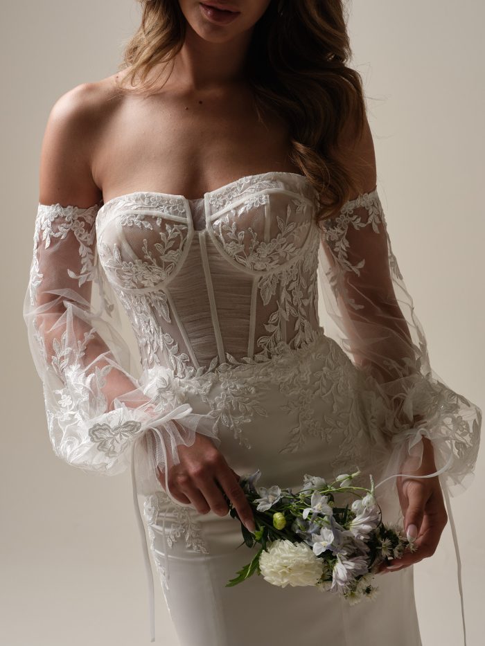 Close-up of Persephone’s corset bodice with floral embroidery and sheer illusion sleeves—this wedding gown is a standout choice for modern brides rewriting tradition.