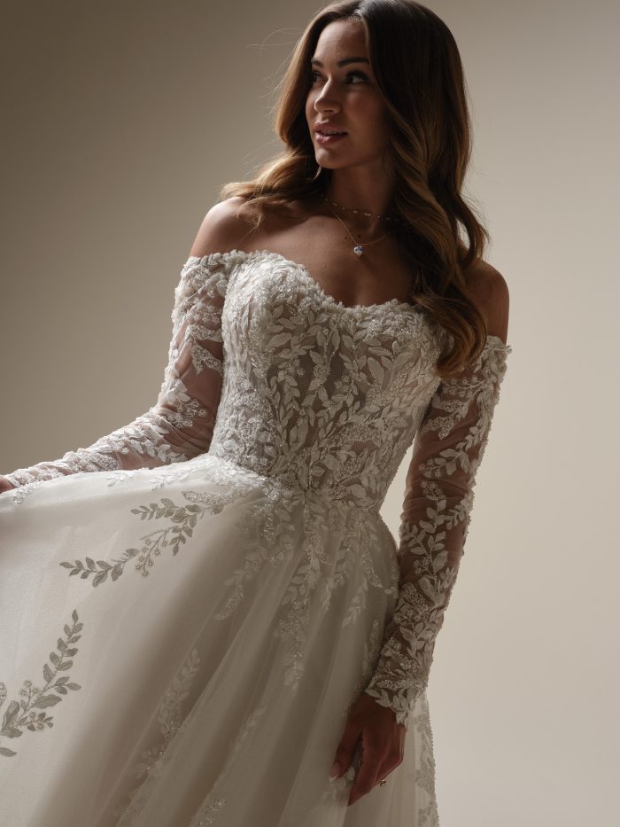 Close-up of the Maggie Sottero Rita A-line wedding dress with off-the-shoulder sleeves and leafy lace embroidery—perfect for wedding dresses for petite brides seeking timeless romance.