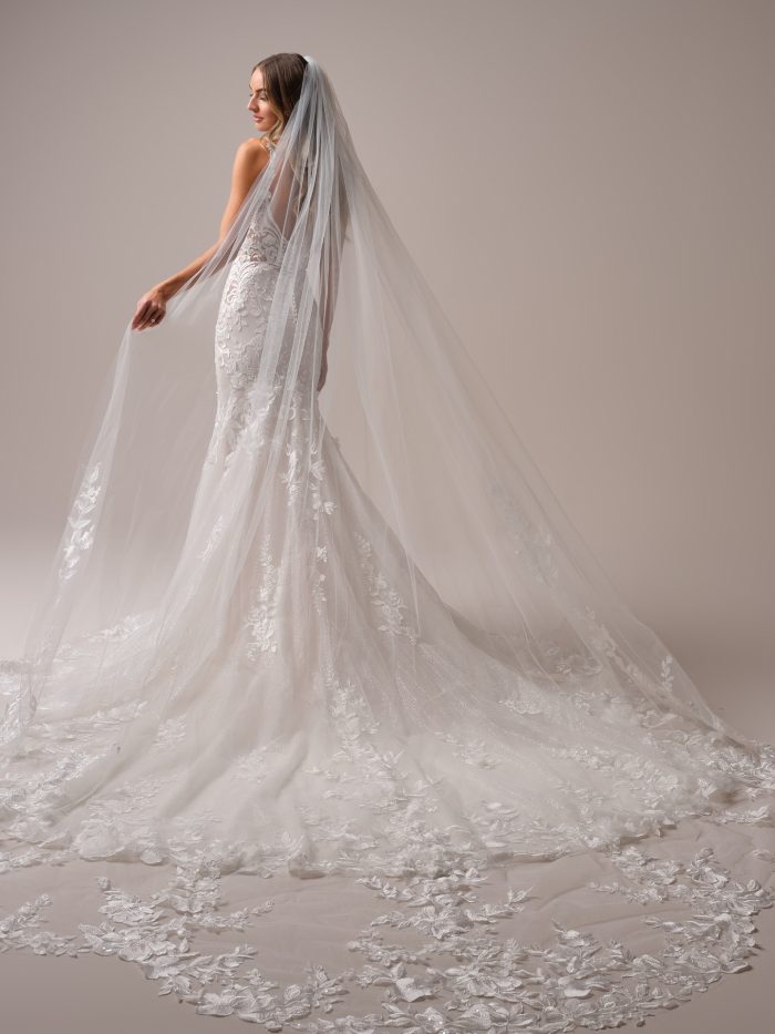 Maggie Sottero Sonoma veil in cathedral length with intricate floral lace appliqués and shimmering tulle. This dramatic long veil adds romantic texture and elegant detail to any wedding dress for a stunning bridal silhouette.