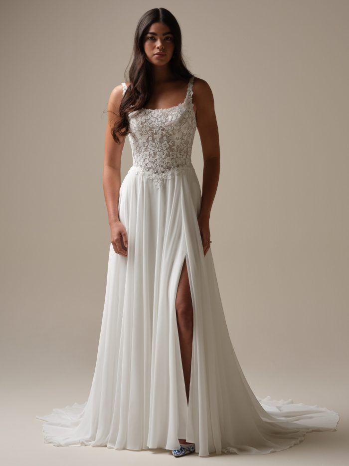 Bride wearing Cory by Rebecca Ingram, a casual chiffon A-line wedding dress with lace bodice, square neckline, and side slit.