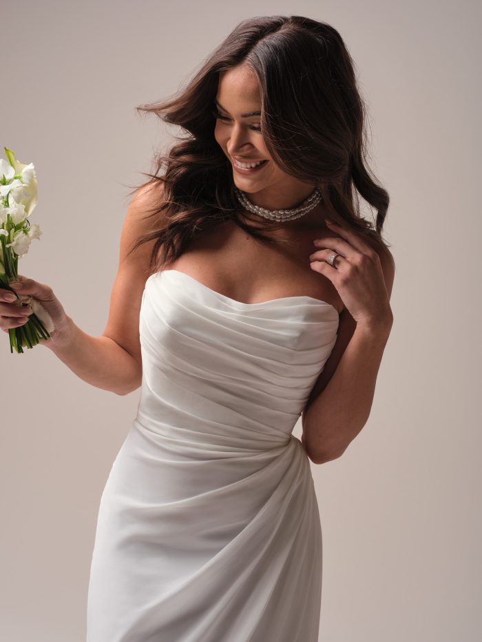 Close-up of Francesca by Rebecca Ingram casual wedding dress with ruched chiffon bodice and strapless scoop neckline.