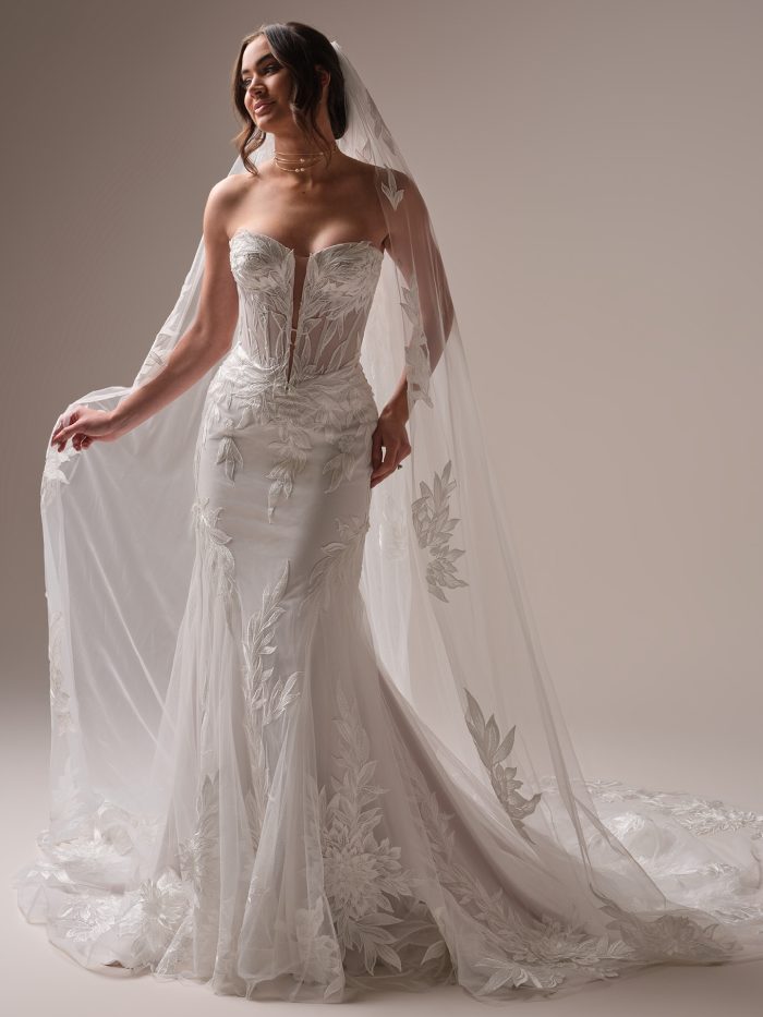 Bride wearing Belladonna, a trending wedding gown with botanical lace, sheer corset bodice, and dramatic veil—made for the modern Gen Z bridal aesthetic.