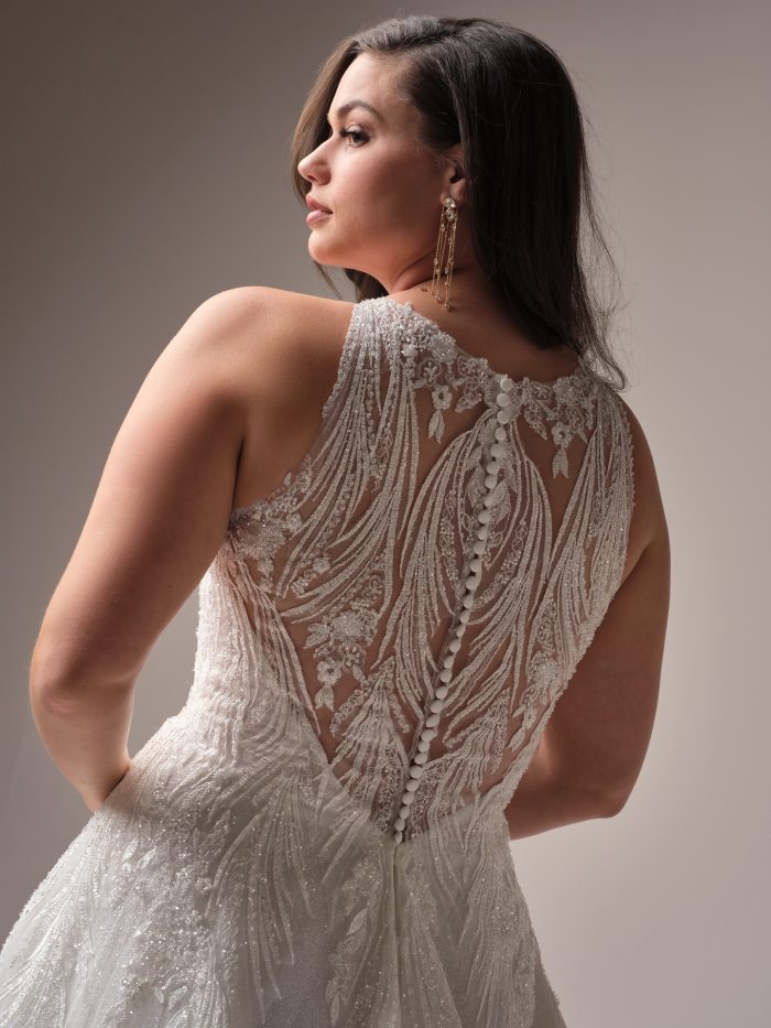 Back view of the Genevieve gown, highlighting the illusion lace back with fabric-covered buttons, beaded embellishments, and cascading embroidery down the full tulle skirt.