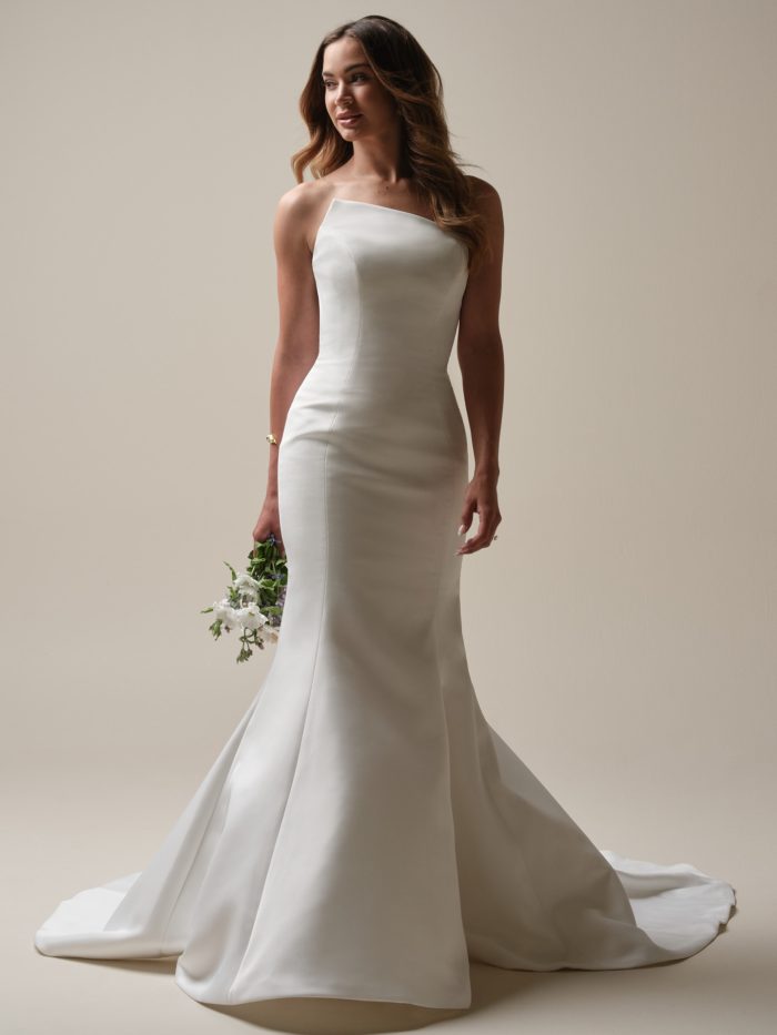Nesrine by Sottero and Midgley modern satin mermaid wedding dress with asymmetrical strapless neckline and minimalist silhouette.