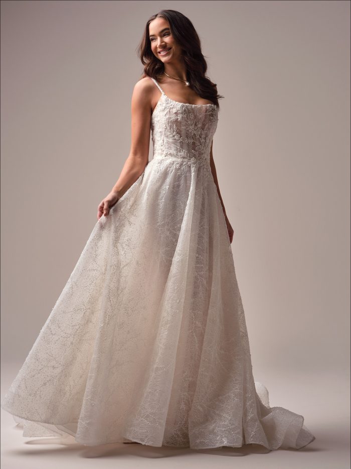 Full-length view of the Maggie Sottero Salvadora A-line wedding dress featuring a sparkling lace overlay, flowing skirt, and a romantic, whimsical silhouette.