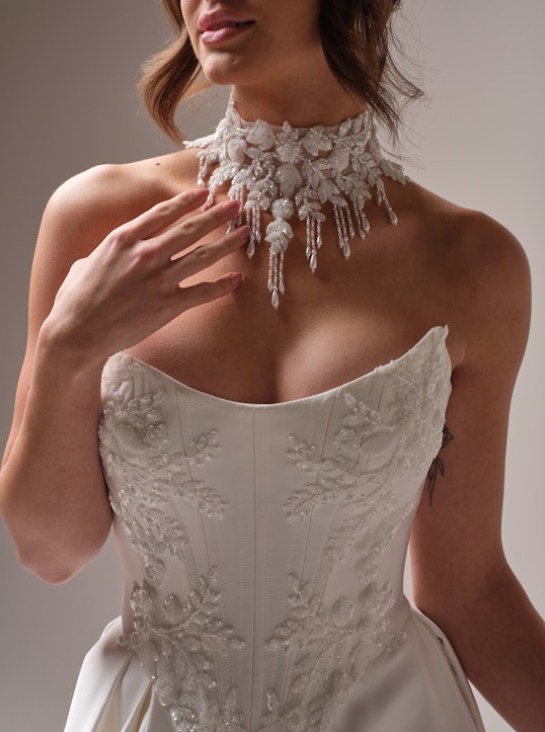 Close-up of a sweetheart neckline wedding gown with floral beaded lace embroidery and a dramatic beaded floral choker necklace.