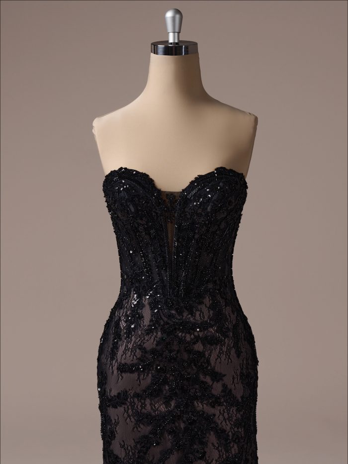 Bodice detail of the Benjie fit-and-flare wedding dress by Maggie Sottero, showcasing a strapless illusion corset with structured boning and black lace appliqués over sheer tulle.