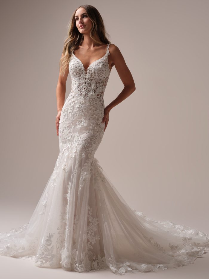 Bride wearing the Maggie Sottero Sonoma fit-and-flare wedding dress featuring a plunging V-neckline, sheer lace bodice with 3D floral appliqués, and a textured tulle skirt with a chapel-length train.