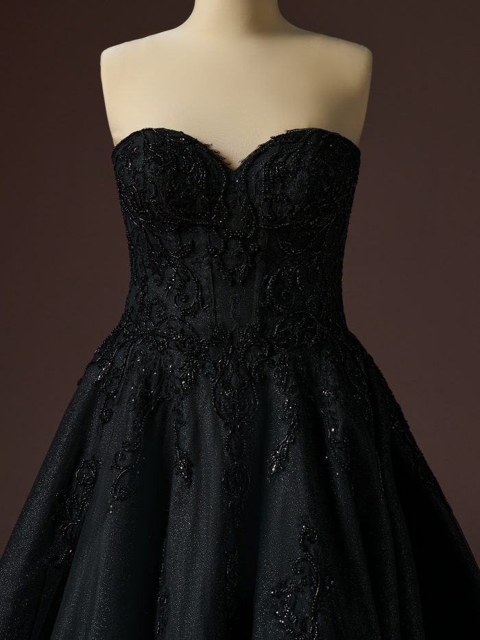 Strapless sweetheart bodice detail of the Gwyneth ballgown wedding dress by Sottero and Midgley, featuring intricate black beaded lace over a structured corset with a full, softly textured skirt.