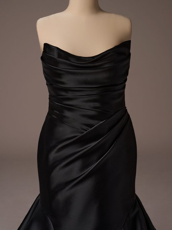 Bodice detail of the Lagos fit-and-flare wedding dress by Sottero and Midgley, highlighting a strapless draped neckline with ruched satin and smooth, fitted shaping through the waist.