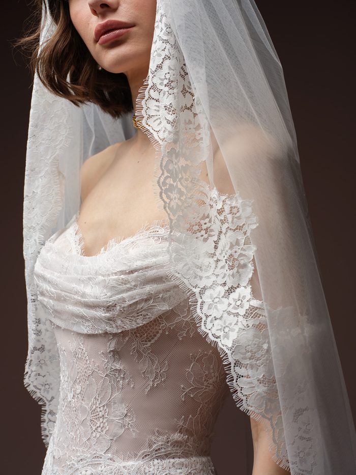 Minuet wedding veil with delicate floral lace edging, styled with the Maelle boho floral wedding dress to showcase romantic lace detailing and soft cathedral-length tulle.