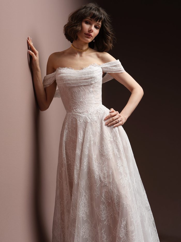 Maelle boho floral wedding dress with detachable off-the-shoulder cap sleeves, featuring delicate allover floral lace, a draped sweetheart neckline, and a soft A-line silhouette for a romantic bridal look.
