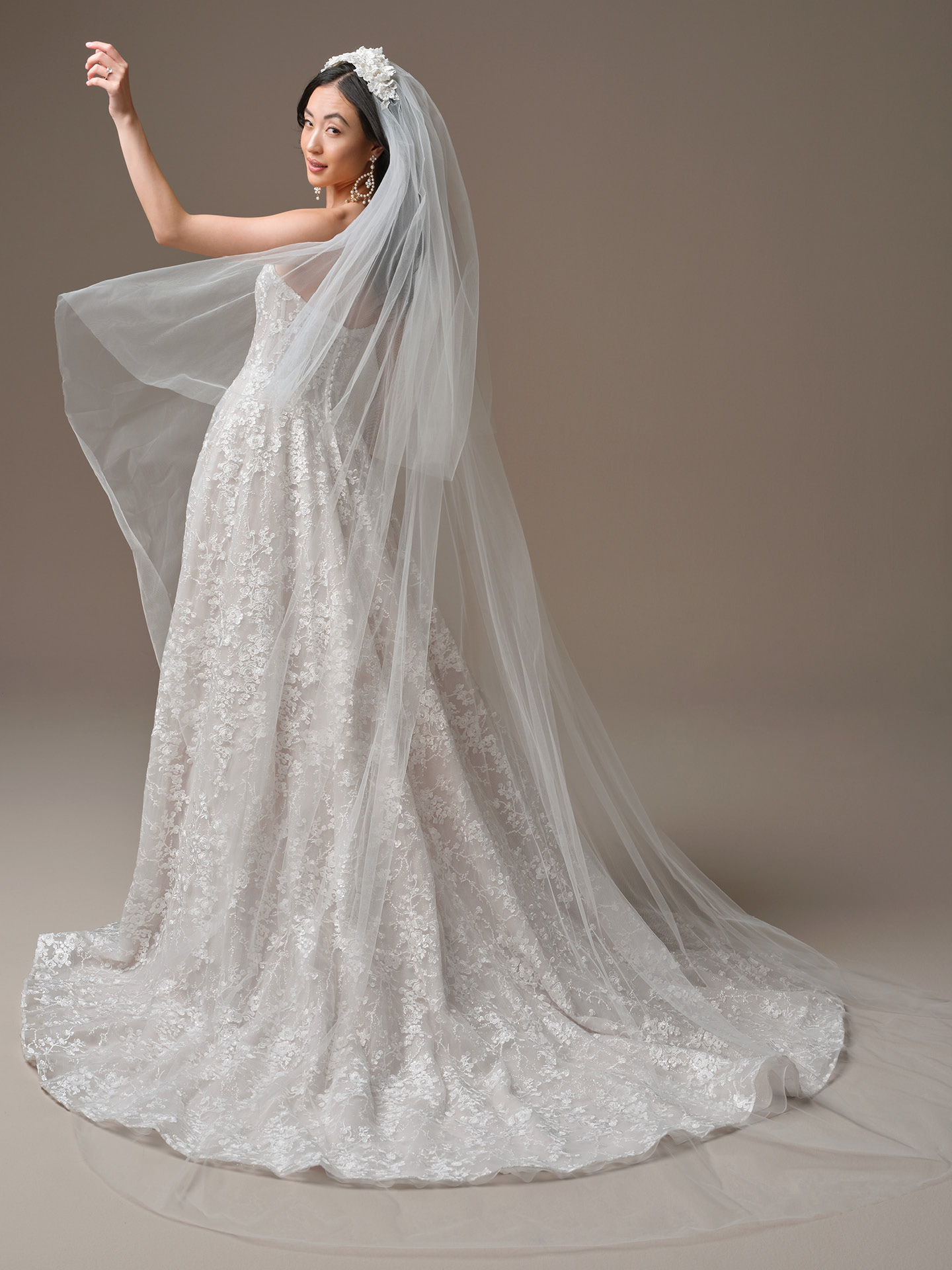 Bride in Memphis by Maggie Sottero styled with a cathedral-length tulle veil, showcasing the shimmering lace ballgown silhouette, illusion bodice detailing, and sweeping train.