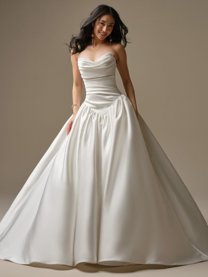 Bride wearing Pasadena by Maggie Sottero, a satin ballgown wedding dress featuring a sculpted basque waist, draped sweetheart neckline, and full gathered skirt.