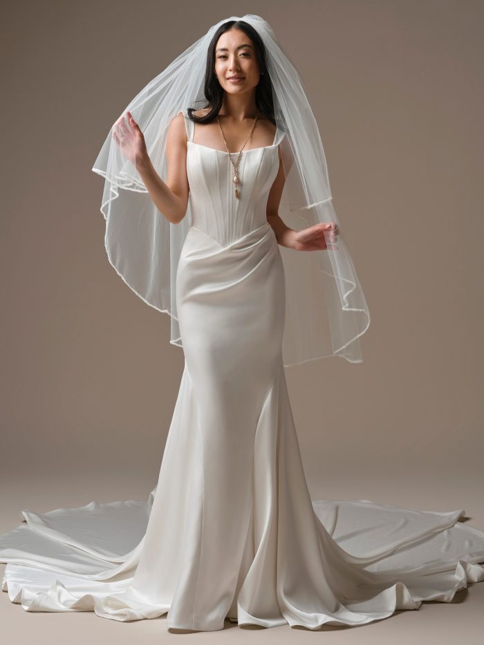 Bride wearing the Santorini veil from Maggie Sottero's Essentials Edit collection, a two-tier veil with beaded edge trim, paired with a satin fitted mermaid wedding gown.