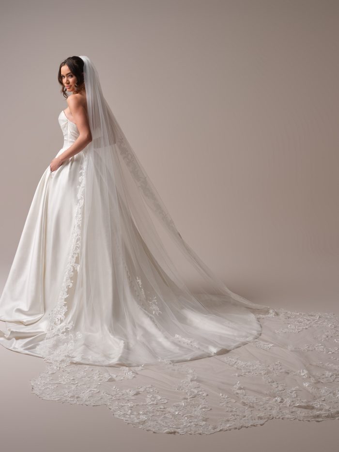 Bride wearing the Maureen veil by Maggie Sottero, a cathedral-length veil with scalloped lace edging, paired with a strapless satin ball gown.