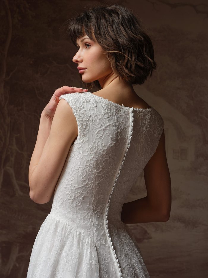 Back detail of the Rebecca Ingram Briar A-line wedding gown featuring floral lace and covered button accents.