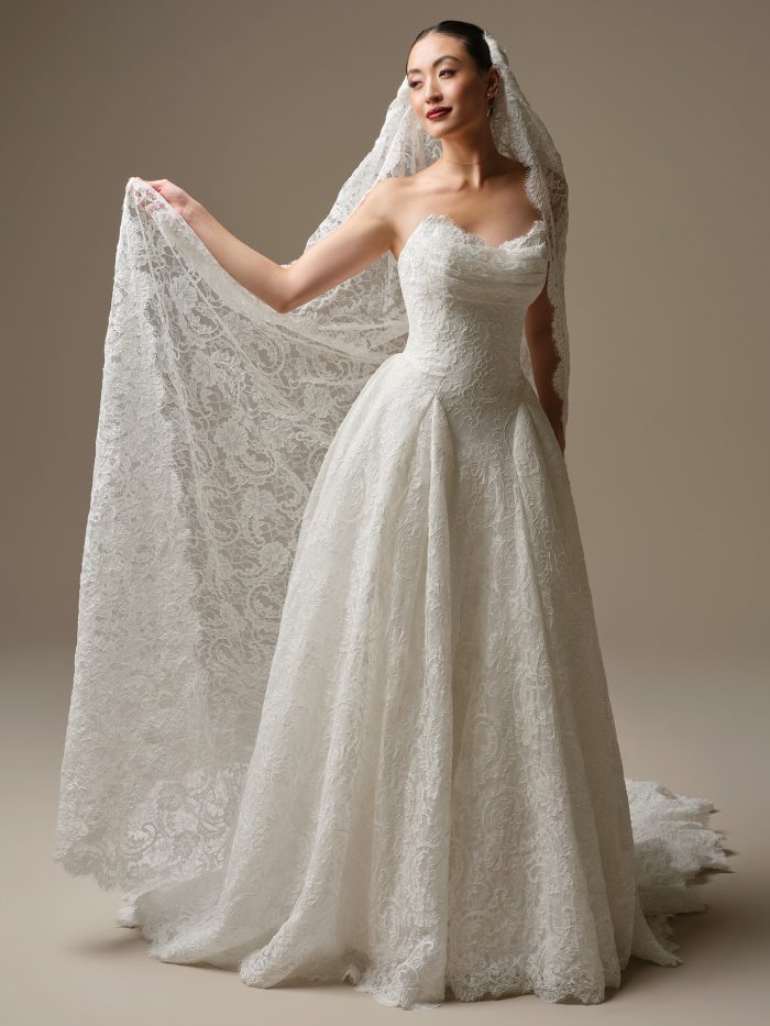 Bride wearing the Tamar A-line wedding dress by Sottero and Midgley, featuring an all-over floral lace bodice and full ball gown skirt, paired with the matching Tamar all-lace veil.