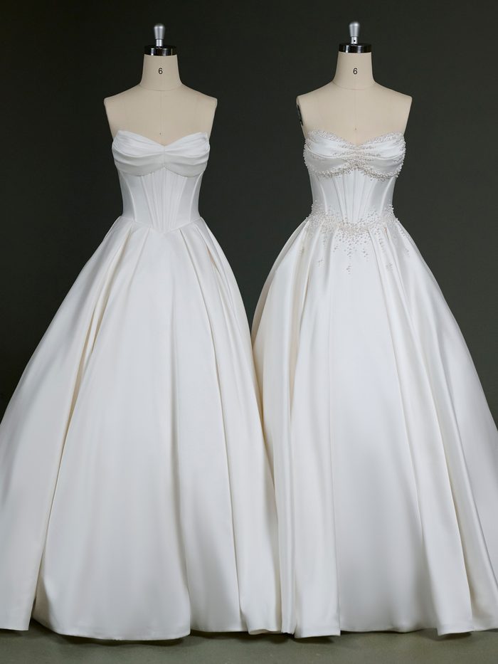 Two versions of the Juneau by Maggie Sottero wedding gown are displayed side by side on dress forms. Both feature a strapless satin ballgown silhouette with a draped sweetheart neckline, corset-inspired bodice, and full pleated skirt. The gown on the left showcases a clean, minimalist design, while the gown on the right is customized with pearl embellishments along the neckline, waist, and upper skirt, adding dimensional sparkle to the classic silhouette.
