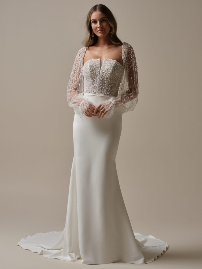 Rebecca Ingram Heyda Sheath Wedding Dress, full-length front view of the strapless pearl-encrusted corset bodice paired with sheer pearl-scattered bishop sleeves with ruffled cuffs, over a sleek crepe sheath skirt with a sweep train.