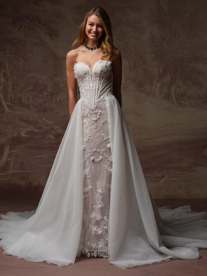 Angel by Maggie Sottero overskirt from the Essentials Edit collection, featuring a voluminous layered tulle overskirt with a dramatic flowing train styled over a fitted bridal gown.