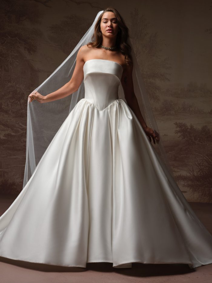 Santorini by Maggie Sottero veil from the Essentials Edit, featuring a sheer cathedral-length tulle design with a soft, flowing drape styled over a structured satin ball gown.