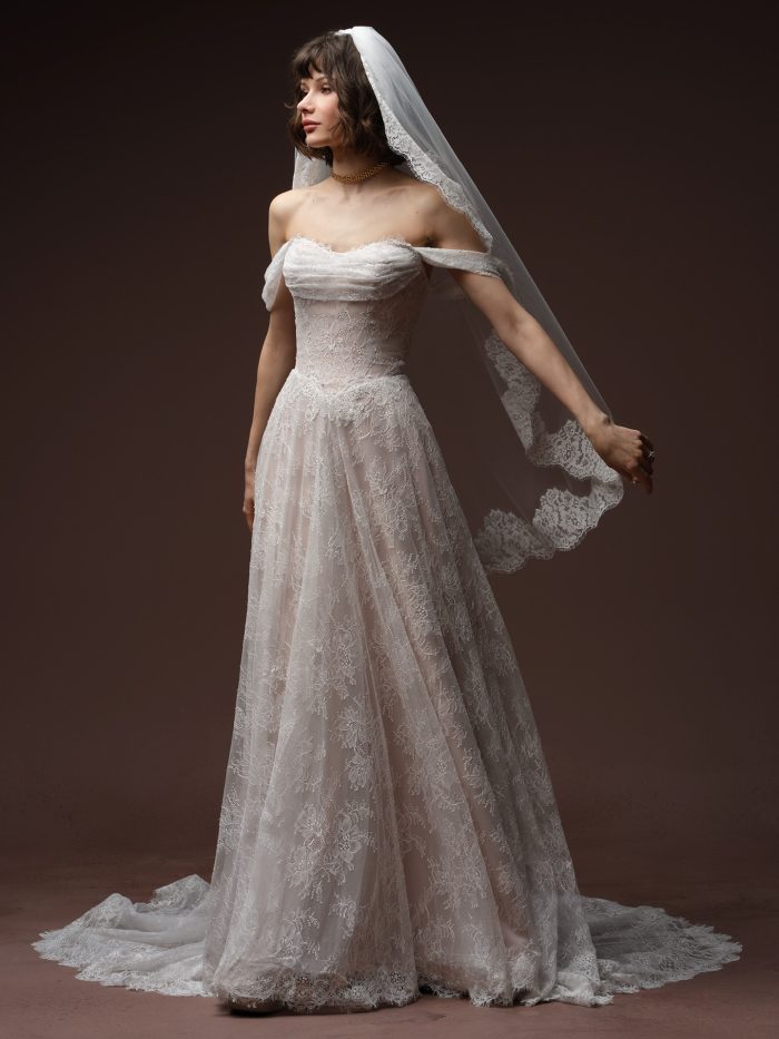 Minuet by Maggie Sottero veil from the Essentials Edit, showcasing a soft fingertip-length tulle veil with scalloped lace edging draped over a lace A-line bridal gown.